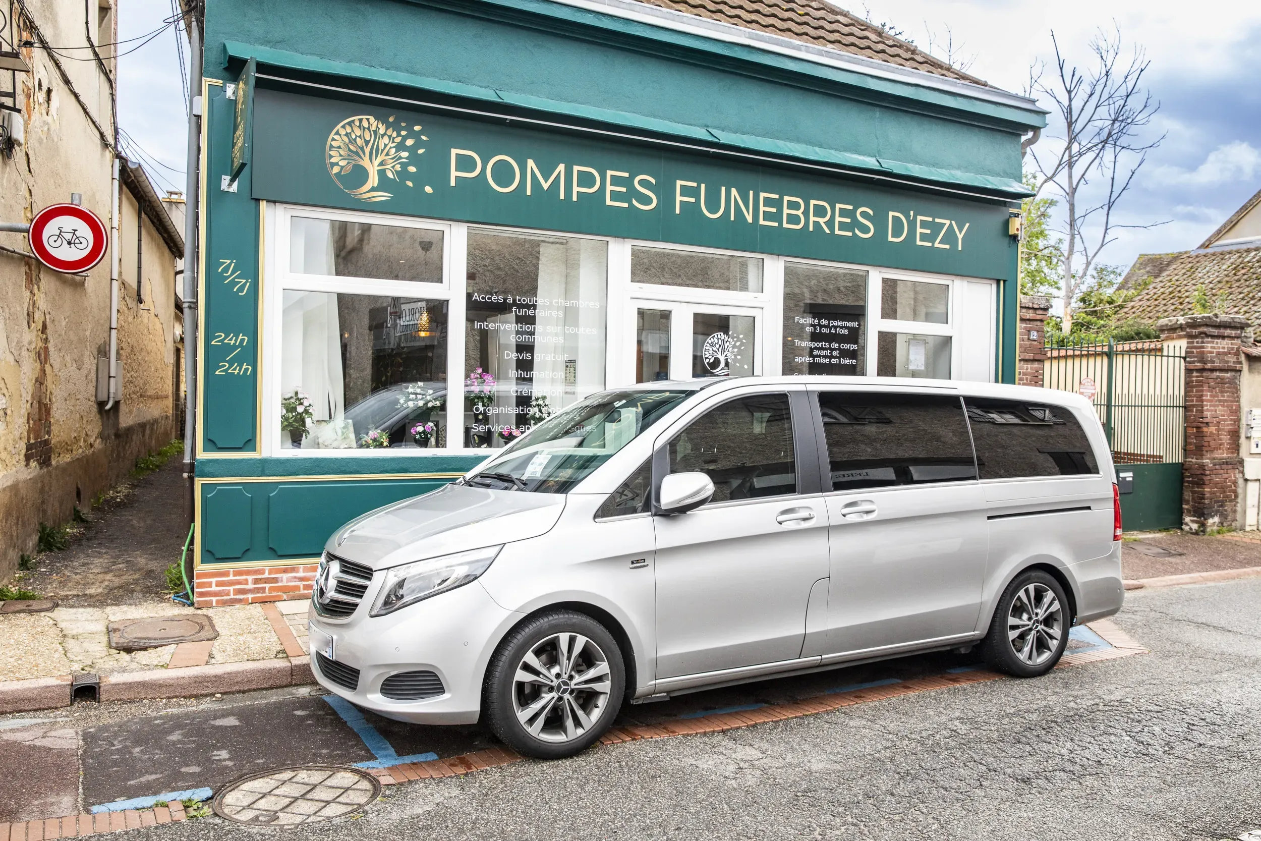 Corbillard Mercedes gris garé devant l'agence des Pompes Funèbres d'Ézy.